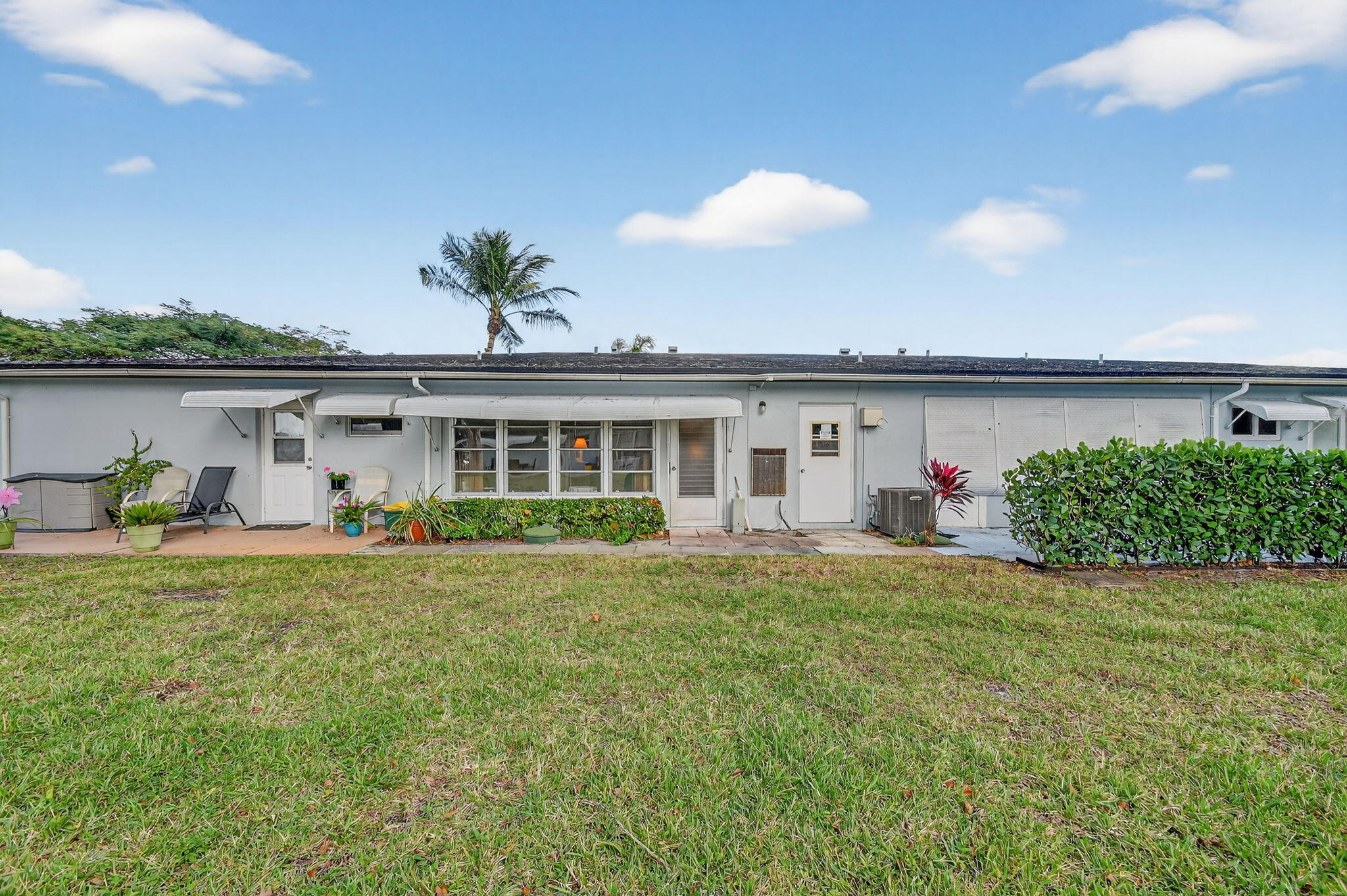 615 High Point Drive, Unit C Delray Beach, FL 33445 - Photo 40 of 48 a front view of a house with a porch and furniture