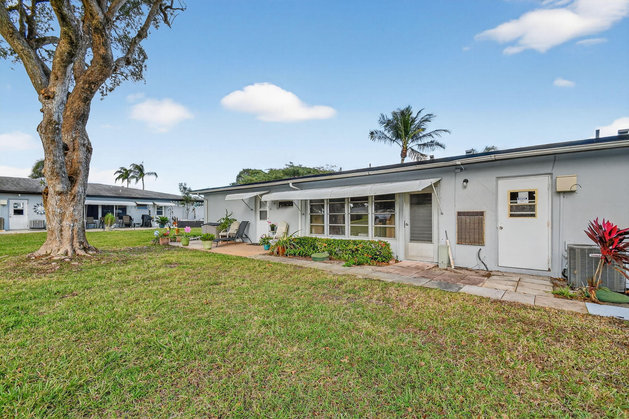 615 High Point Drive, Unit C Delray Beach, FL 33445 - Photo 41 of 48 a front view of a house with a yard and porch