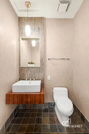 a bathroom with a sink a toilet and a mirror
