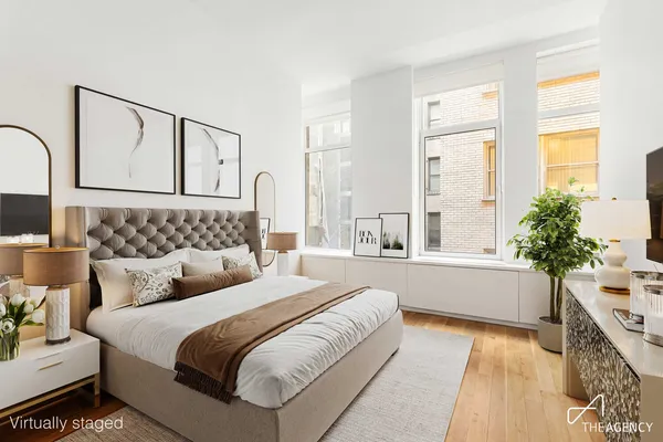 a spacious bedroom with a large bed and a potted plant