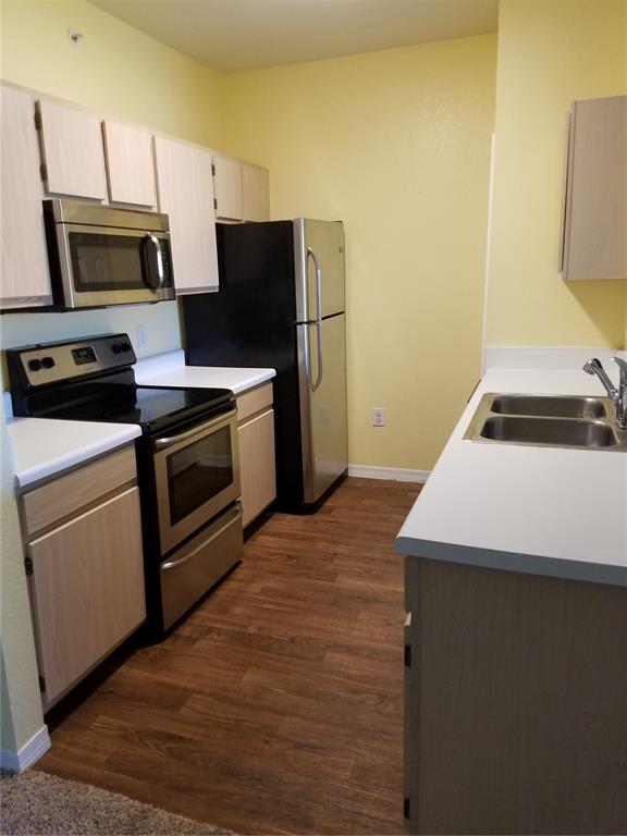5455 Vineland Road, Unit 3303 Orlando, FL 32811 - Photo 8 of 8 a kitchen with a sink a stove top oven and refrigerator