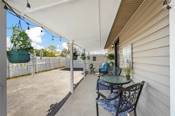 a view of a patio with table and chairs and potted plants