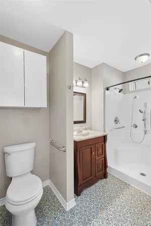 a bathroom with a sink a toilet and shower