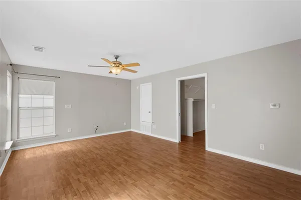 a view of an empty room with wooden floor