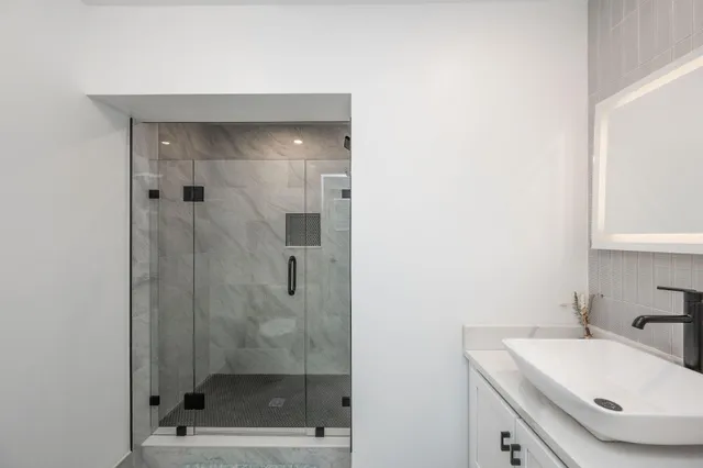 a bathroom with a double vanity sink toilet and shower