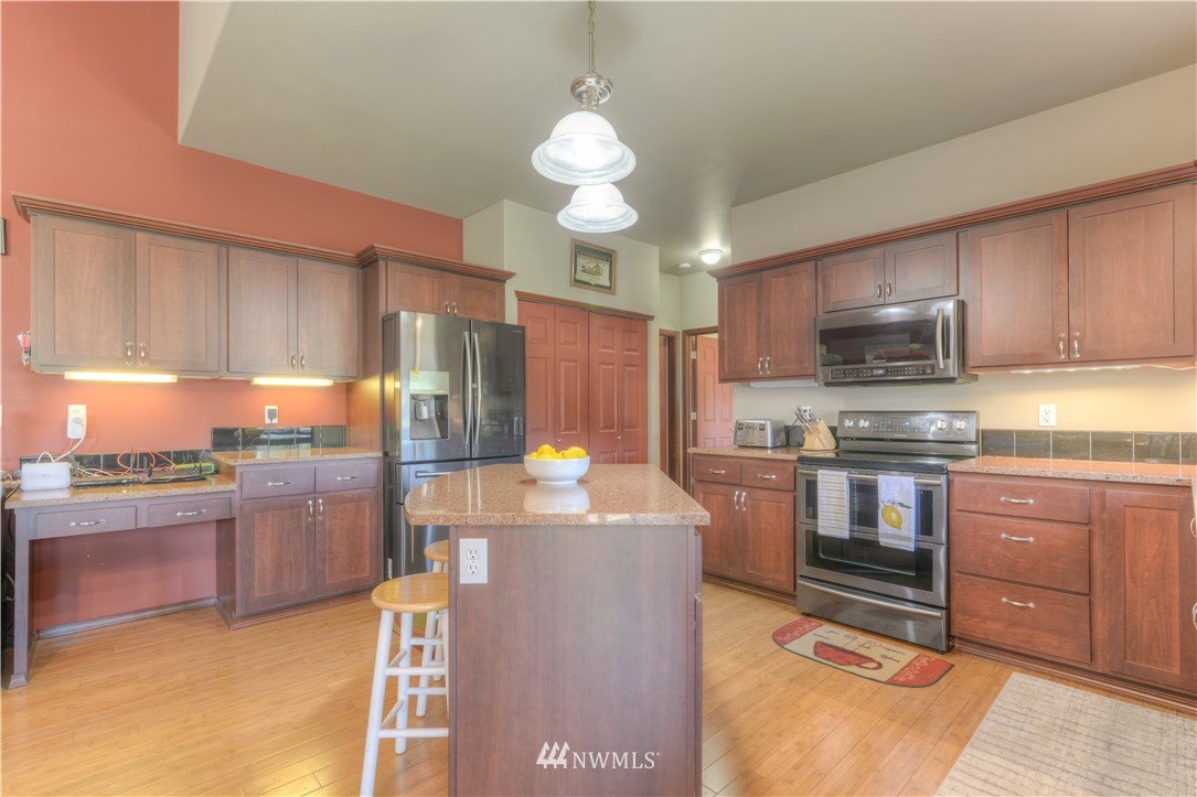 8422 180th Way Southwest Rochester, WA 98579 - Photo 13 of 34 a kitchen with stainless steel appliances granite countertop a stove refrigerator and a sink