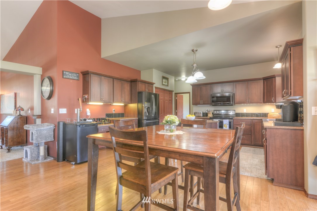 8422 180th Way Southwest Rochester, WA 98579 - Photo 14 of 34 a dining area with stainless steel appliances kitchen island granite countertop a table chairs and a kitchen view