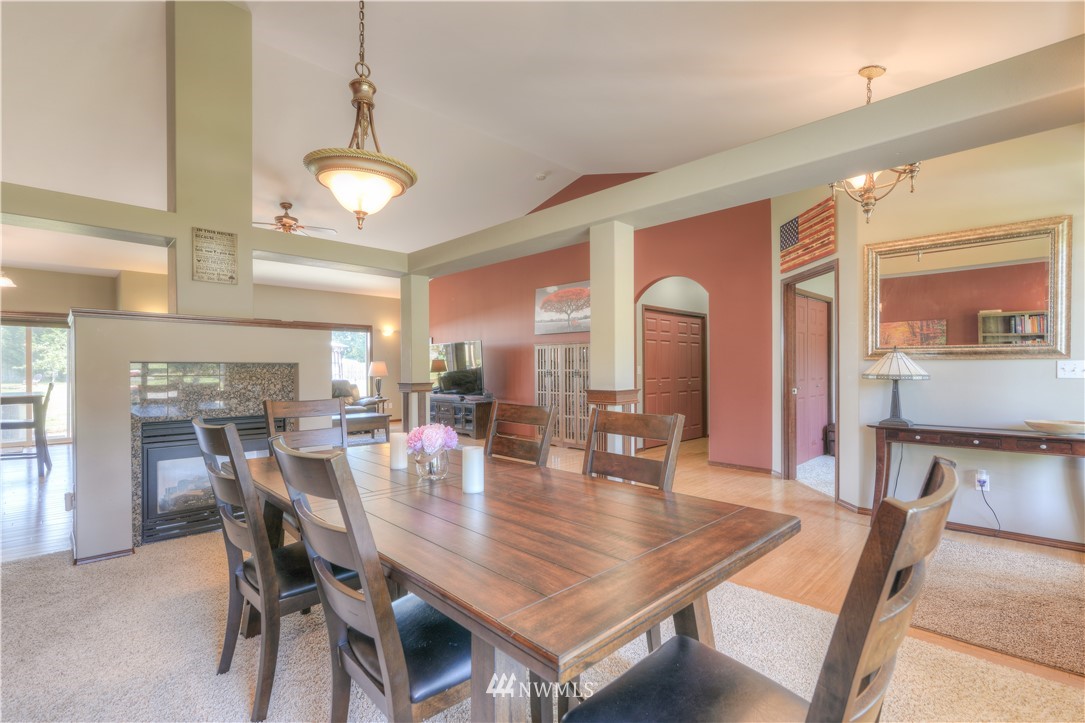 8422 180th Way Southwest Rochester, WA 98579 - Photo 17 of 34 a dining room with wooden floor a chandelier a wooden table and chairs