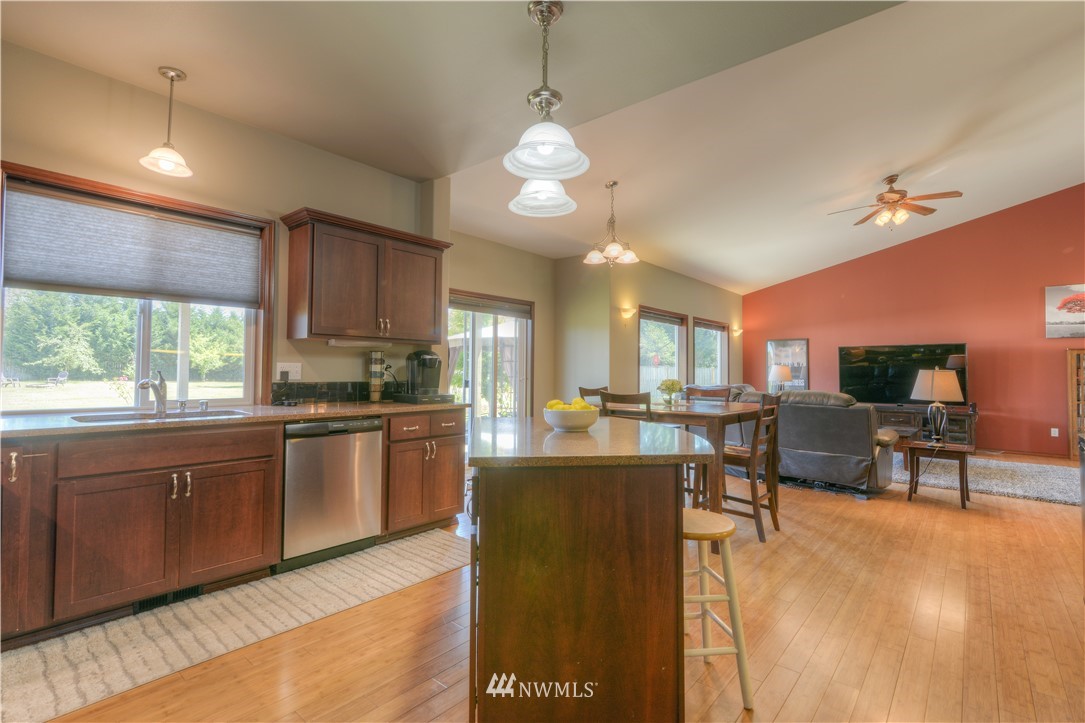 8422 180th Way Southwest Rochester, WA 98579 - Photo 18 of 34 a large kitchen with kitchen island a sink a stove a dining table and chairs