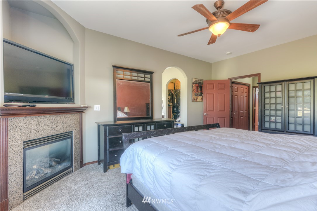 8422 180th Way Southwest Rochester, WA 98579 - Photo 23 of 34 a bedroom with a bed and a fireplace