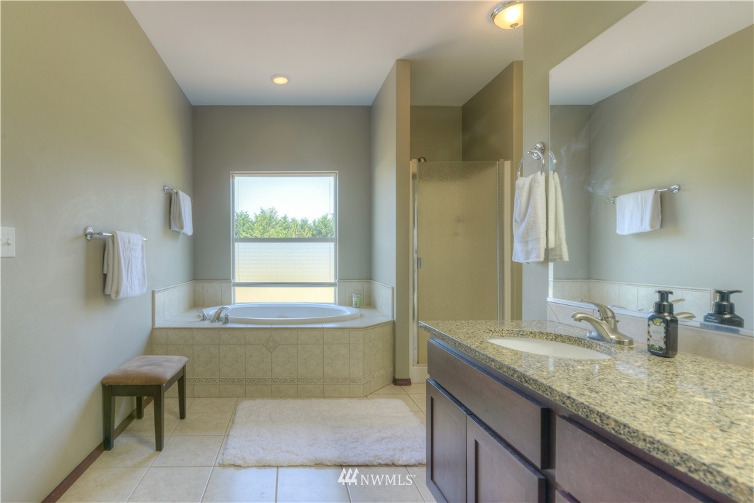8422 180th Way Southwest Rochester, WA 98579 - Photo 25 of 34 a bathroom with a granite countertop sink and a bathtub