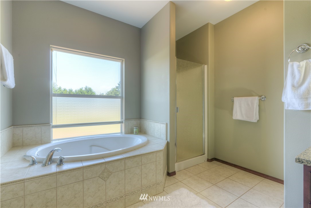 8422 180th Way Southwest Rochester, WA 98579 - Photo 26 of 34 a bathroom with a sink a bathtub and next to a window