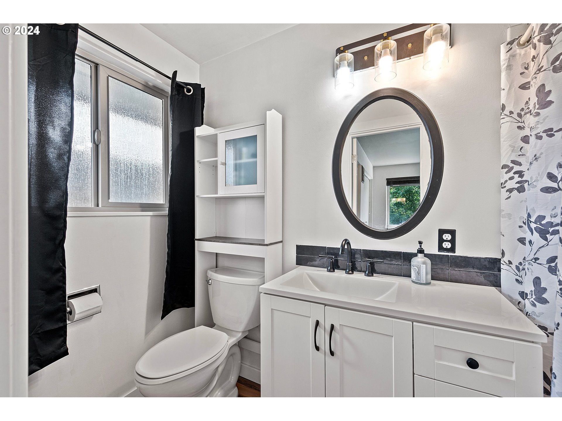 390 Cambridge Street Springfield, OR 97477 - Photo 23 of 48 a bathroom with a sink a mirror a toilet and a window