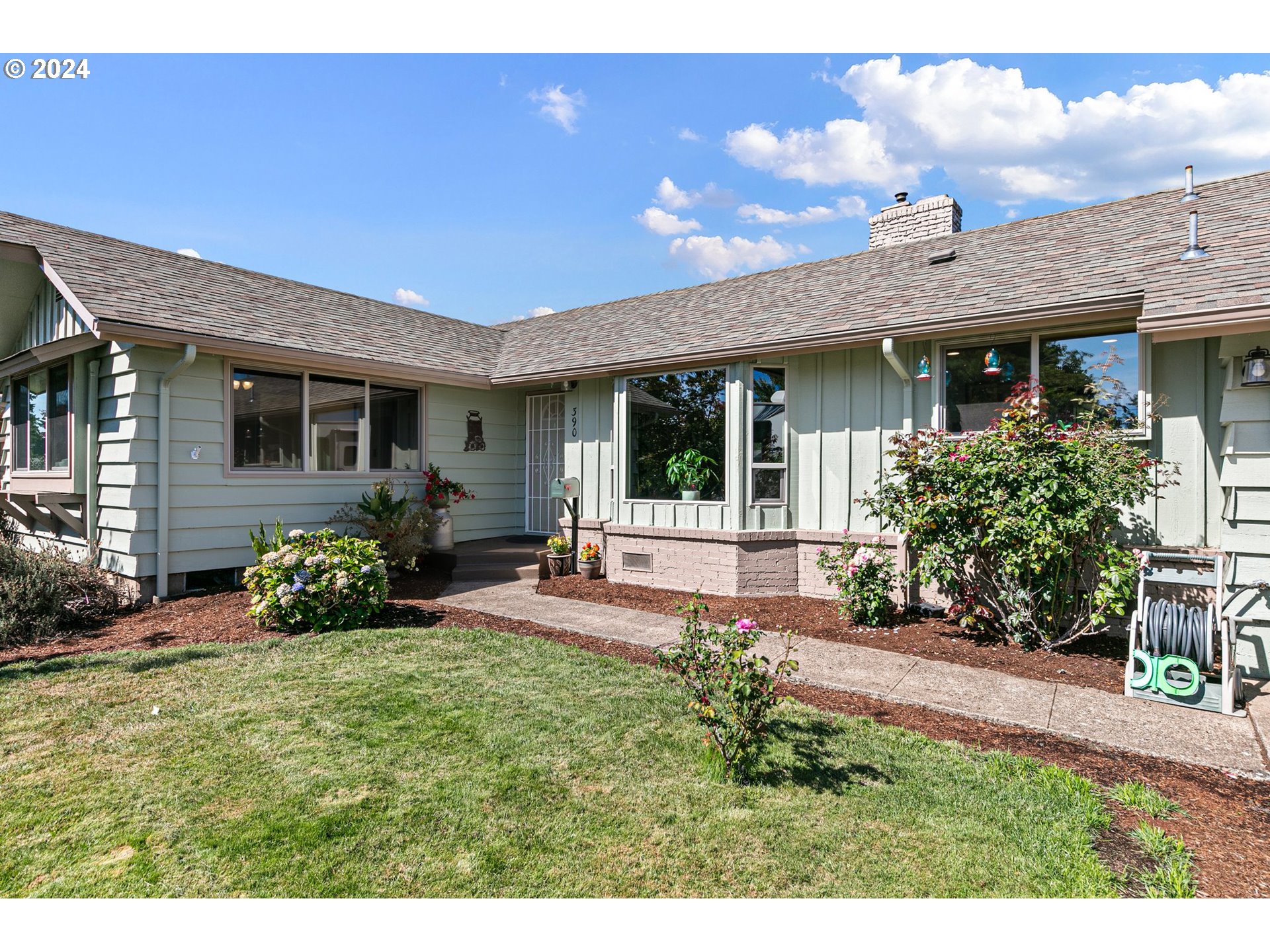 390 Cambridge Street Springfield, OR 97477 - Photo 5 of 48 a view of a house with potted plants and a bench