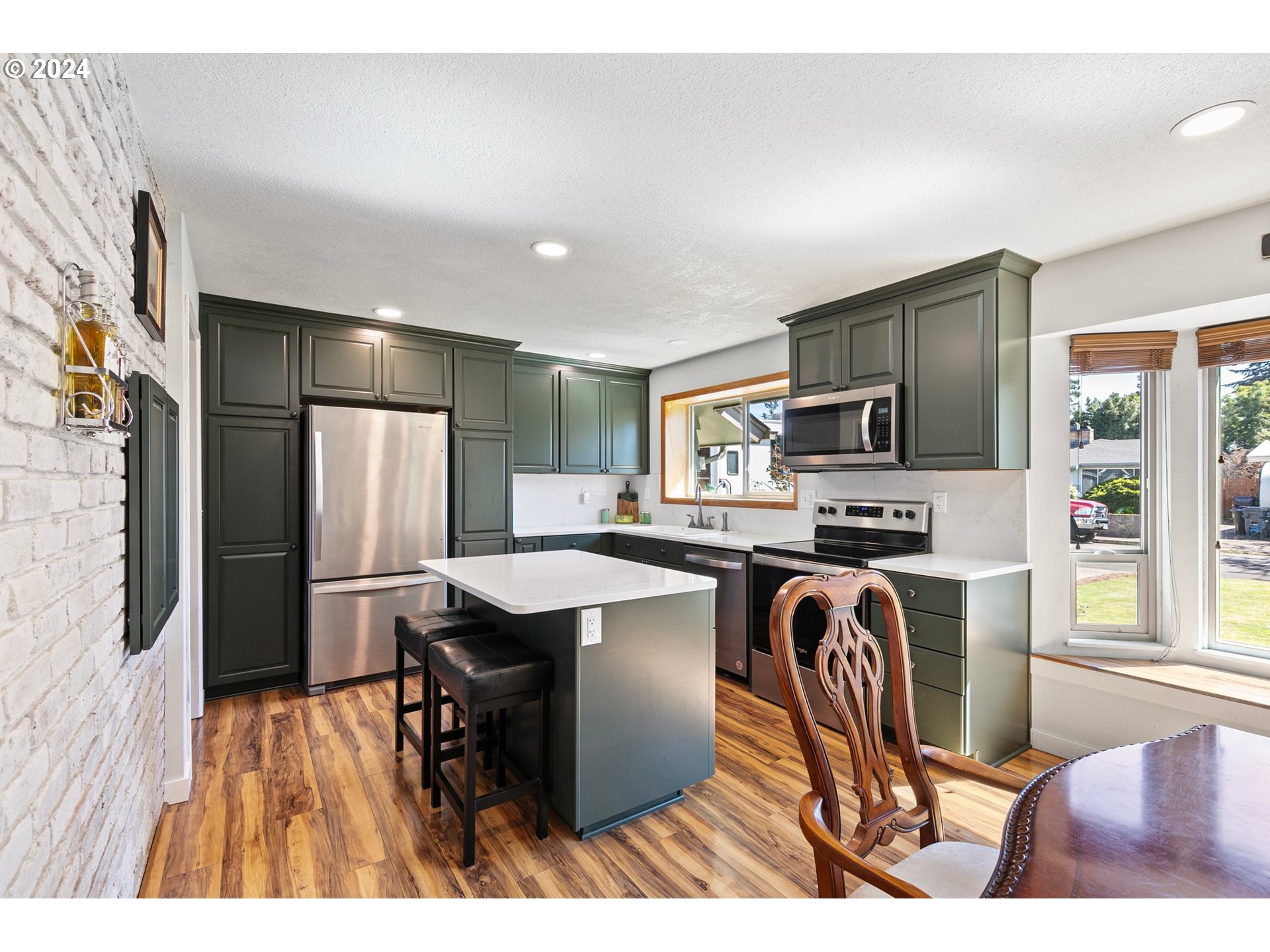 390 Cambridge Street Springfield, OR 97477 - Photo 8 of 48 a kitchen with stainless steel appliances a refrigerator a stove a sink dishwasher and white cabinets with wooden floor
