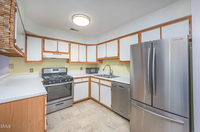 a kitchen with stainless steel appliances granite countertop a refrigerator stove and sink