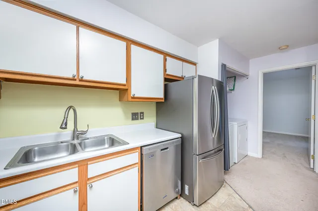 a kitchen with stainless steel appliances a sink and a refrigerator