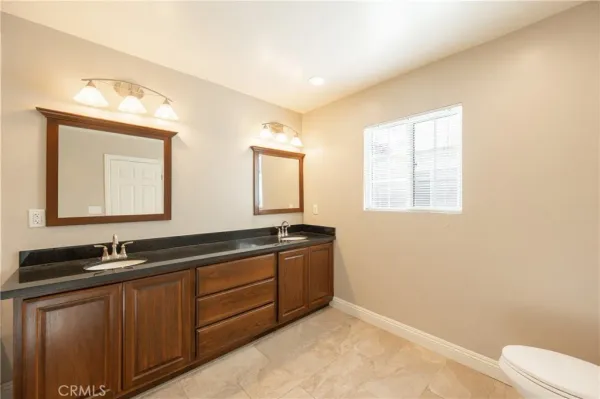 a bathroom with double sink and a mirror