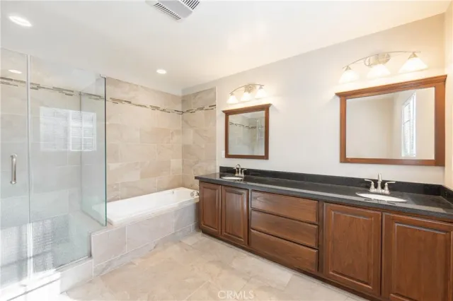 a bathroom with a bathtub shower sink and mirror