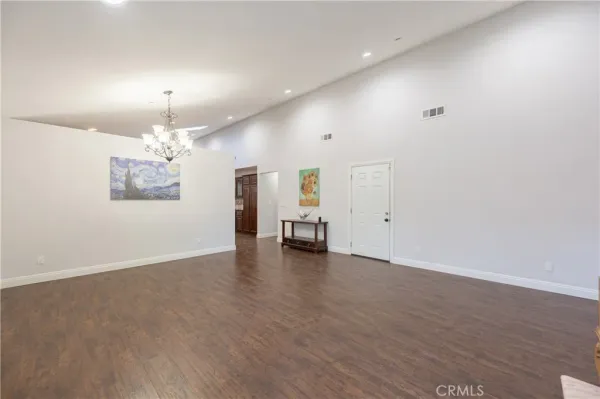 an empty room with wooden floor and furniture
