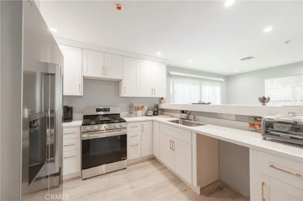 a kitchen with stainless steel appliances white cabinets and a refrigerator