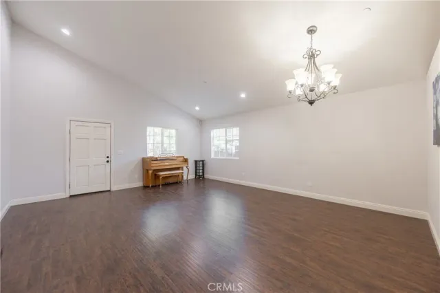 a view of empty room with wooden floor and window