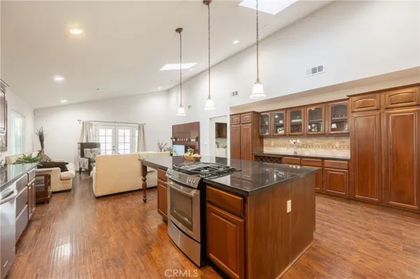a kitchen with stainless steel appliances granite countertop a stove a sink and a refrigerator
