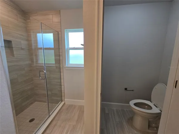 a bathroom with a toilet and a shower
