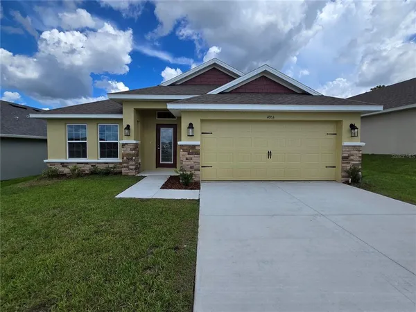 a front view of a house with a garden and plants