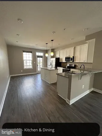 a view of kitchen with cabinets wooden floor and a window