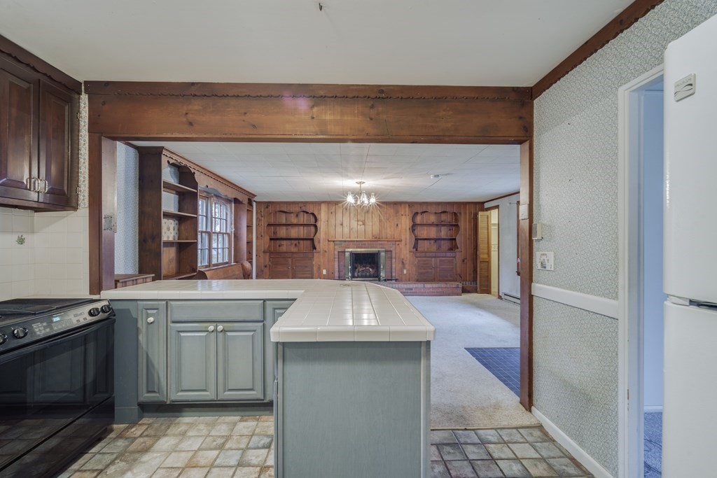 80 Embassy Road Springfield, MA 01119 - Photo 8 of 38 a kitchen with kitchen island granite countertop a stove sink and cabinets