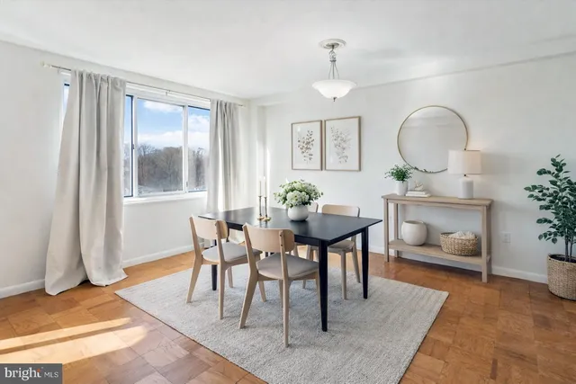 a dining room with wooden floor a glass table and chairs