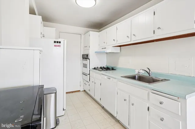 a kitchen with a sink a stove and cabinets