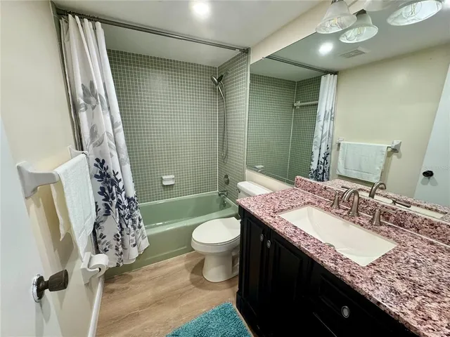 a dinning room with stainless steel appliances granite countertop a dining table chairs and a refrigerator