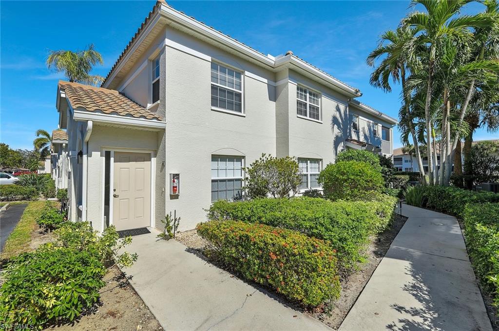 6812 Satinleaf Road South, Unit 204 Naples, FL 34109 - Photo 1 of 39 a front view of a house with garden