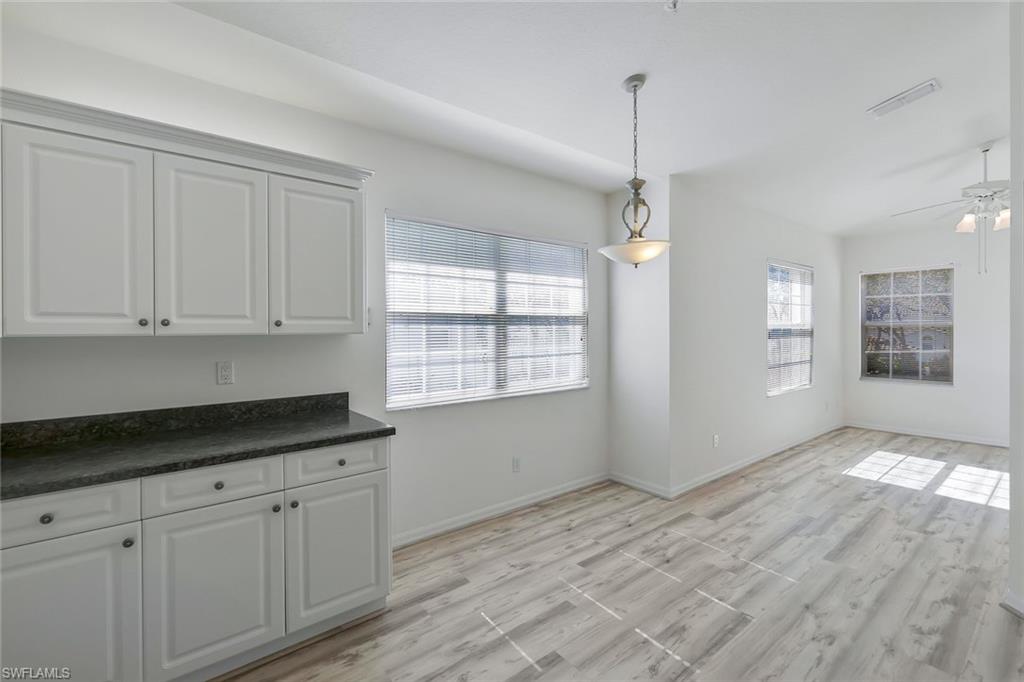 6812 Satinleaf Road South, Unit 204 Naples, FL 34109 - Photo 13 of 39 a kitchen with granite countertop white cabinets and window