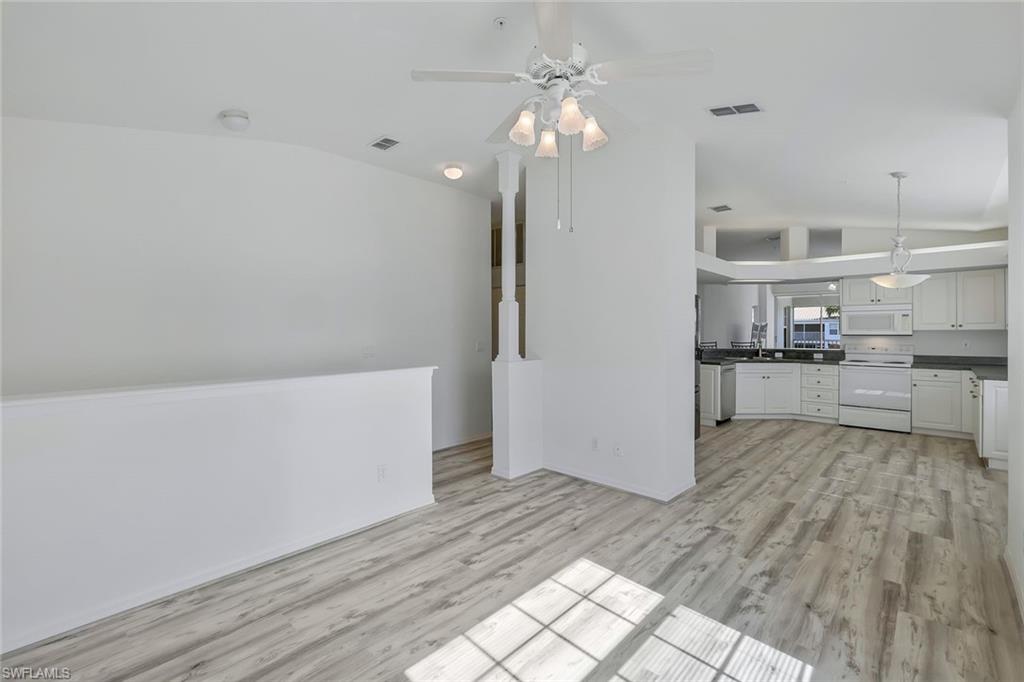 6812 Satinleaf Road South, Unit 204 Naples, FL 34109 - Photo 18 of 39 a view of kitchen with cabinets and wooden floor