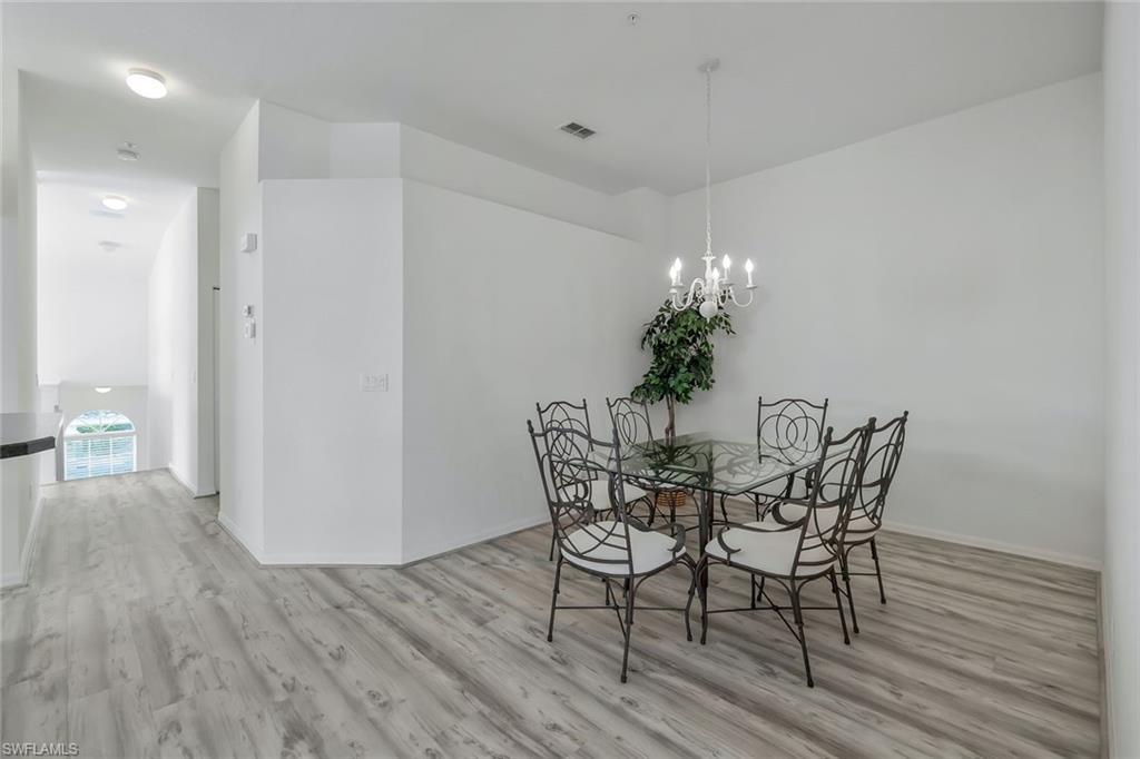 6812 Satinleaf Road South, Unit 204 Naples, FL 34109 - Photo 21 of 39 a view of a dining room with furniture and wooden floor