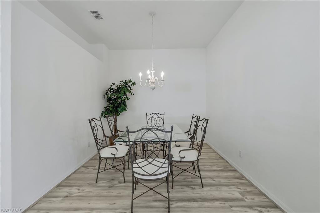 6812 Satinleaf Road South, Unit 204 Naples, FL 34109 - Photo 22 of 39 a view of a dining room with furniture and wooden floor