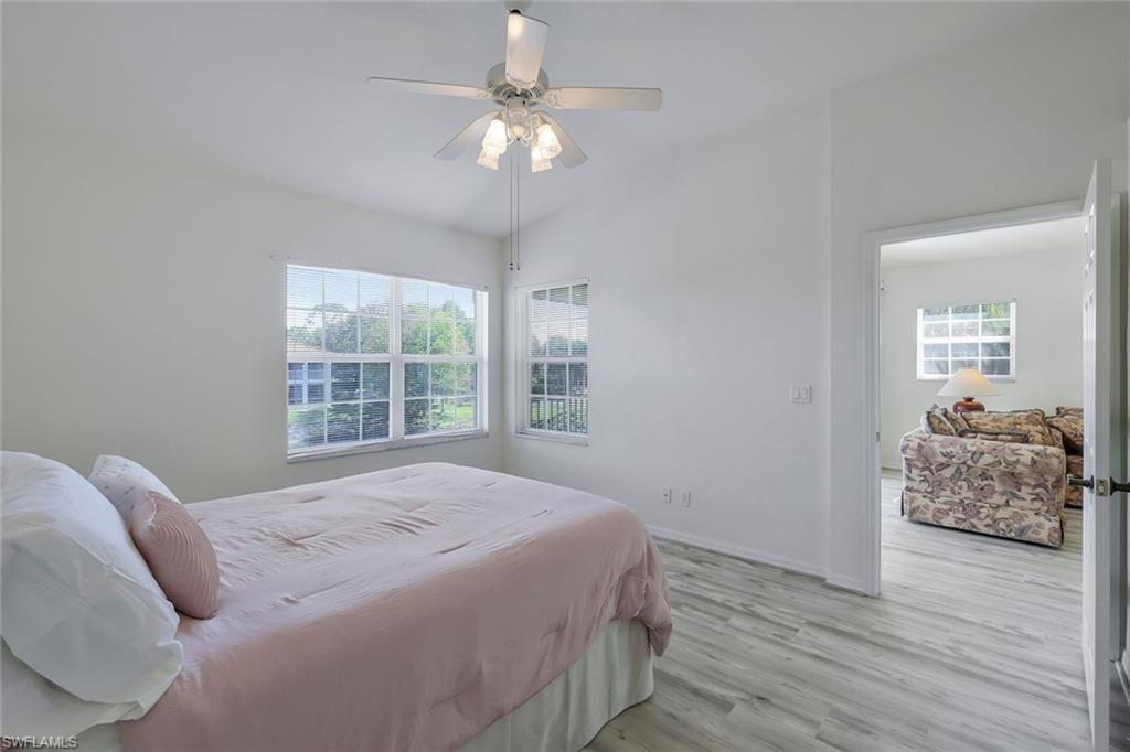 6812 Satinleaf Road South, Unit 204 Naples, FL 34109 - Photo 25 of 39 a bedroom with a bed and a chandelier