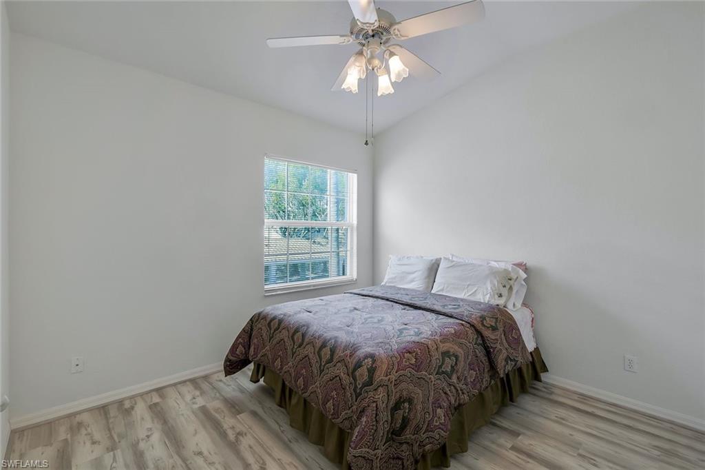 6812 Satinleaf Road South, Unit 204 Naples, FL 34109 - Photo 27 of 39 a bed sitting in a bedroom next to a window
