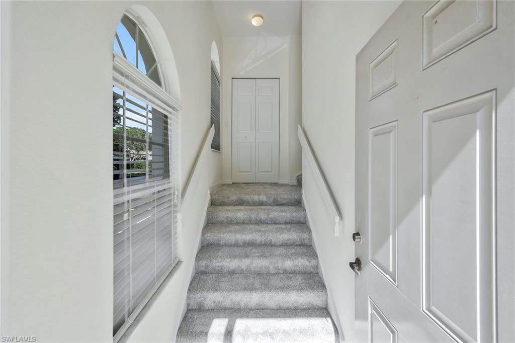6812 Satinleaf Road South, Unit 204 Naples, FL 34109 - Photo 3 of 39 a view of staircase with lots of frames on wall and a large window