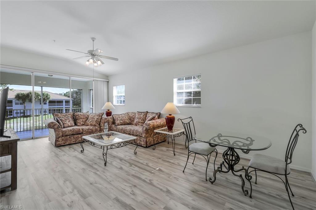 6812 Satinleaf Road South, Unit 204 Naples, FL 34109 - Photo 5 of 39 a living room with furniture and wooden floor
