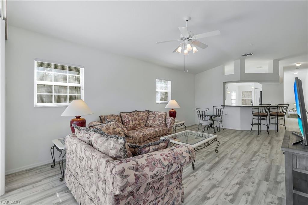 6812 Satinleaf Road South, Unit 204 Naples, FL 34109 - Photo 6 of 39 a living room with furniture and a wooden floor