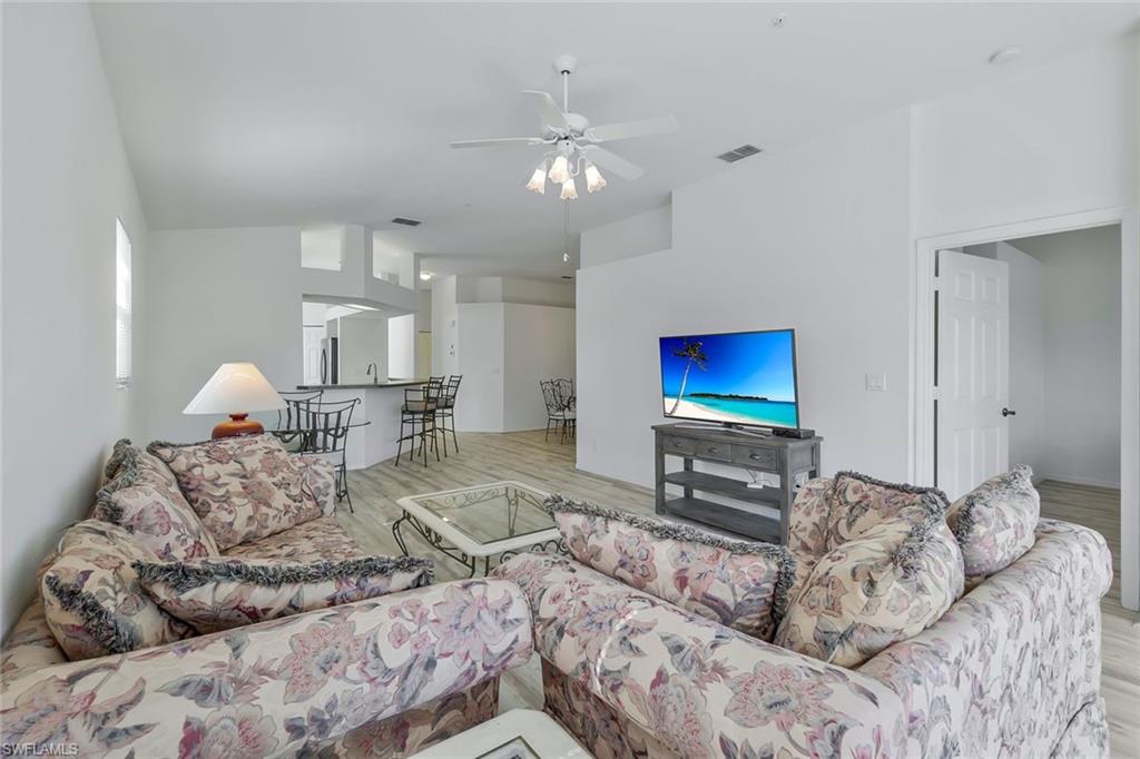 6812 Satinleaf Road South, Unit 204 Naples, FL 34109 - Photo 7 of 39 a living room with furniture and a flat screen tv