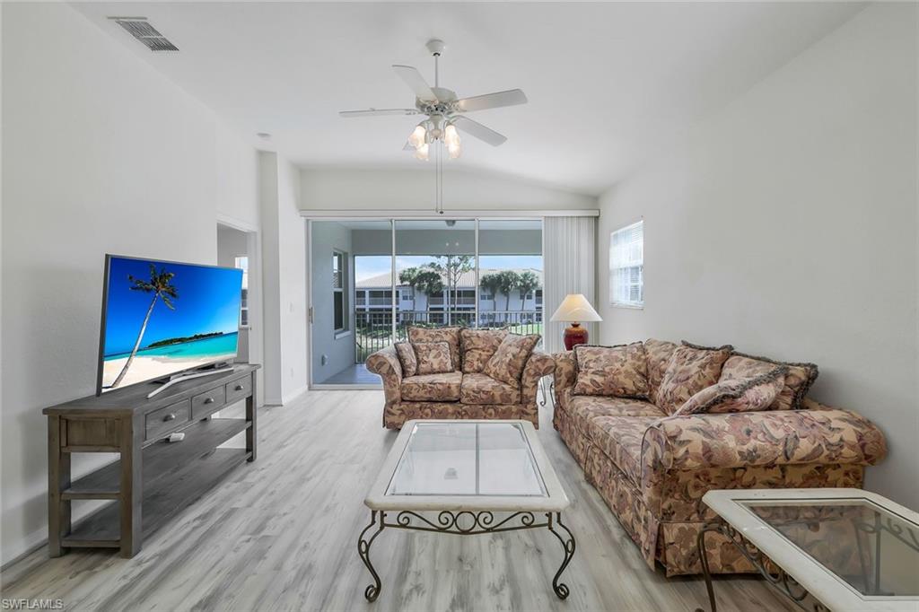 6812 Satinleaf Road South, Unit 204 Naples, FL 34109 - Photo 8 of 39 a living room with furniture and a fireplace