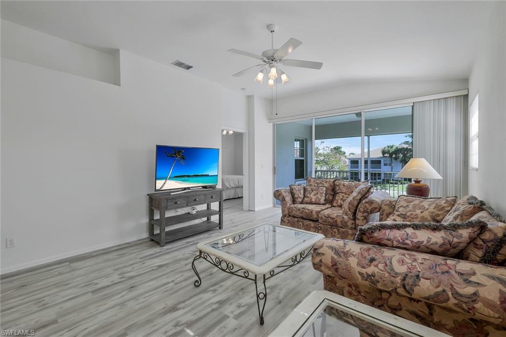 6812 Satinleaf Road South, Unit 204 Naples, FL 34109 - Photo 9 of 39 a living room with furniture and a flat screen tv