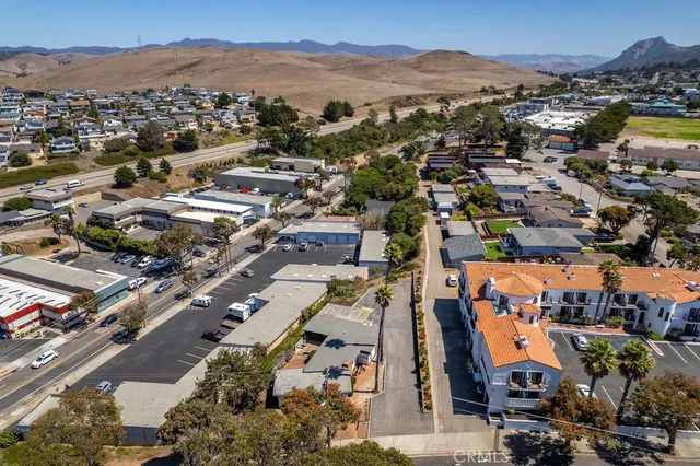 an aerial view of a city with lots of residential buildings and mountain view in back