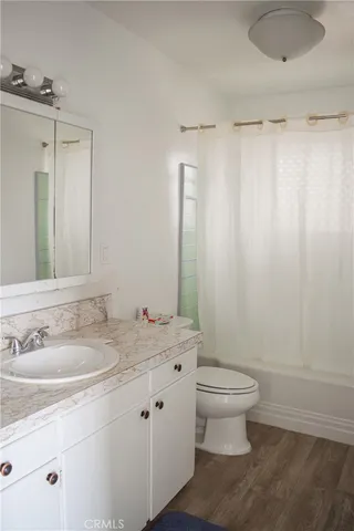 a bathroom with a granite countertop sink a toilet and a mirror