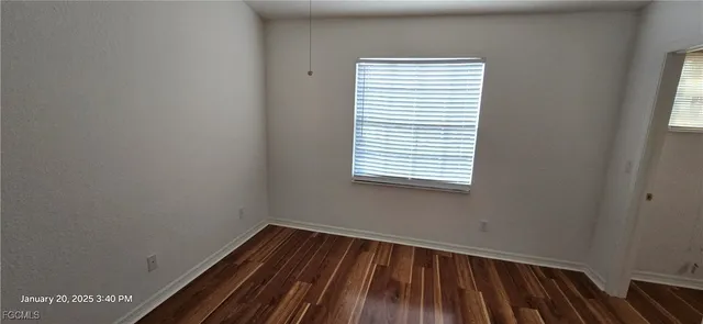 a view of a room with wooden floor and a window